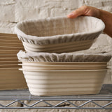 Stack of four batard bannetons; the top two are covered with liners.